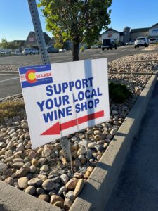 A sign in a shopping plaza in Arvada, Colorado attempt to direct attention. Grocery store wine sales are drawing shopper away from independents retailers. many just yards away.