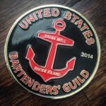 The Fernet coins are a Guild play on the military tradition of coins representing missions, which were then used in Officers’ Clubs. The coins here are used to challenge the buying of a round with others in the Guild who are present.