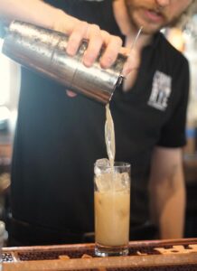 Crafting the Cork & Rye Gastropub’s Uptown Girl cocktail.