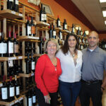 Caron Besek, sales representative, Worldwide Wines, visiting with store owners Daniela and David Tristine.