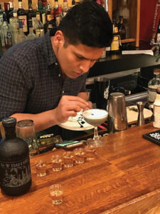 Angel Pena-Fernadez adding garnish to his cocktail creation.